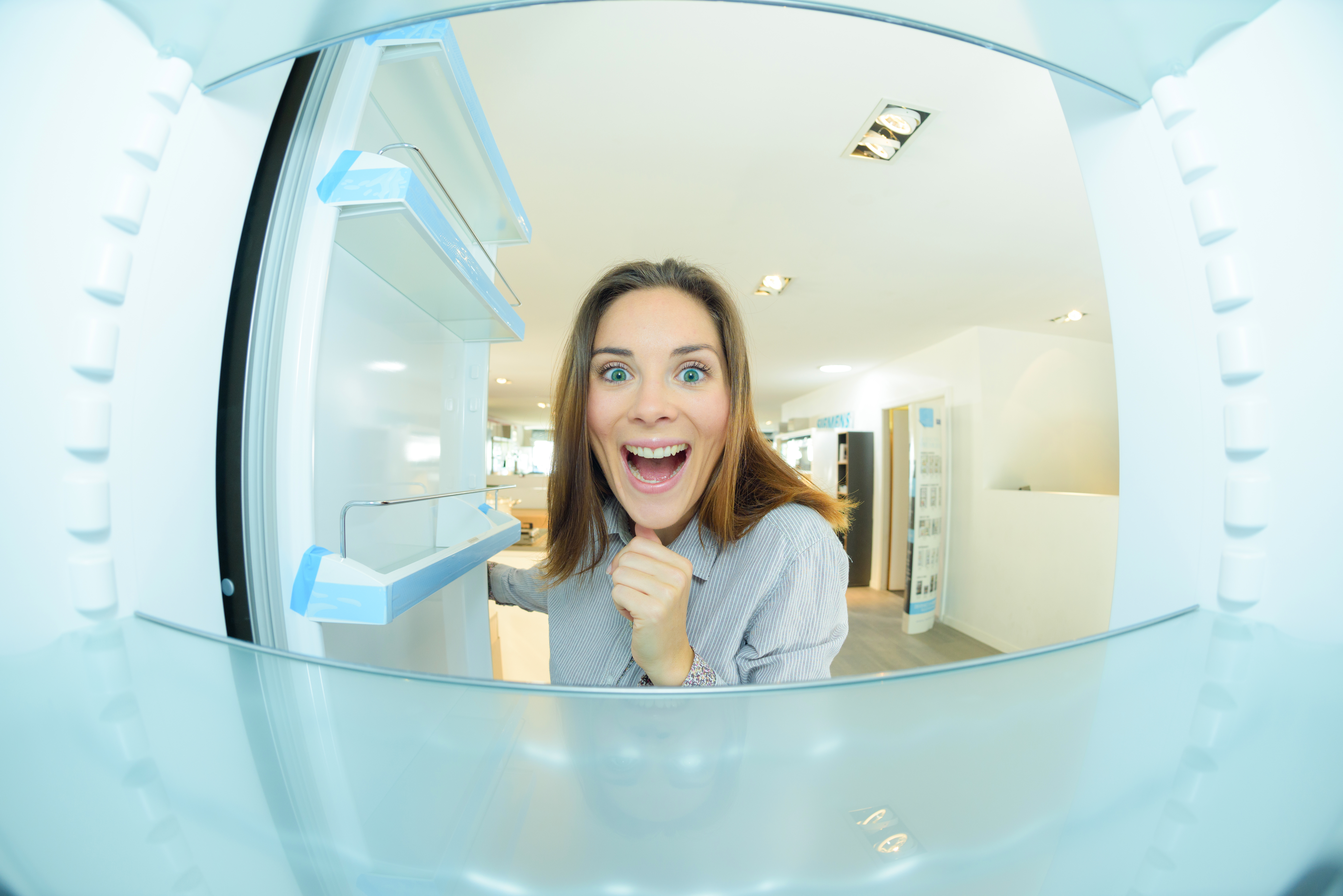 Frau schaut in einen Kühlschrank