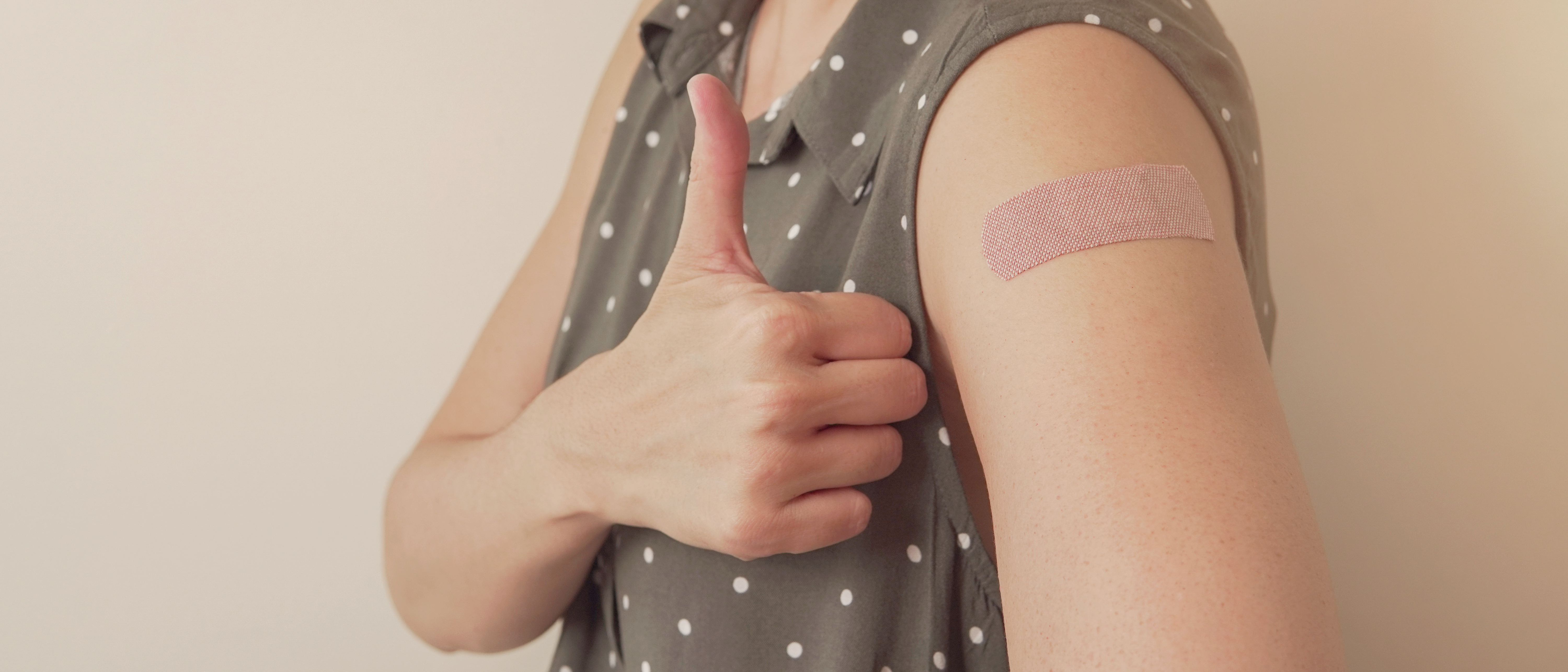 Oberarm mit Plaster und Daumen nach oben
