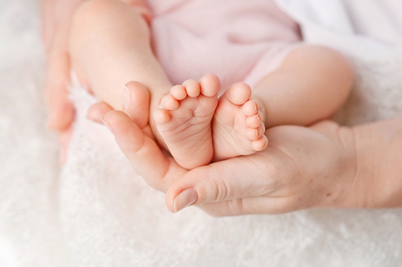 Hände halten Babyfüße