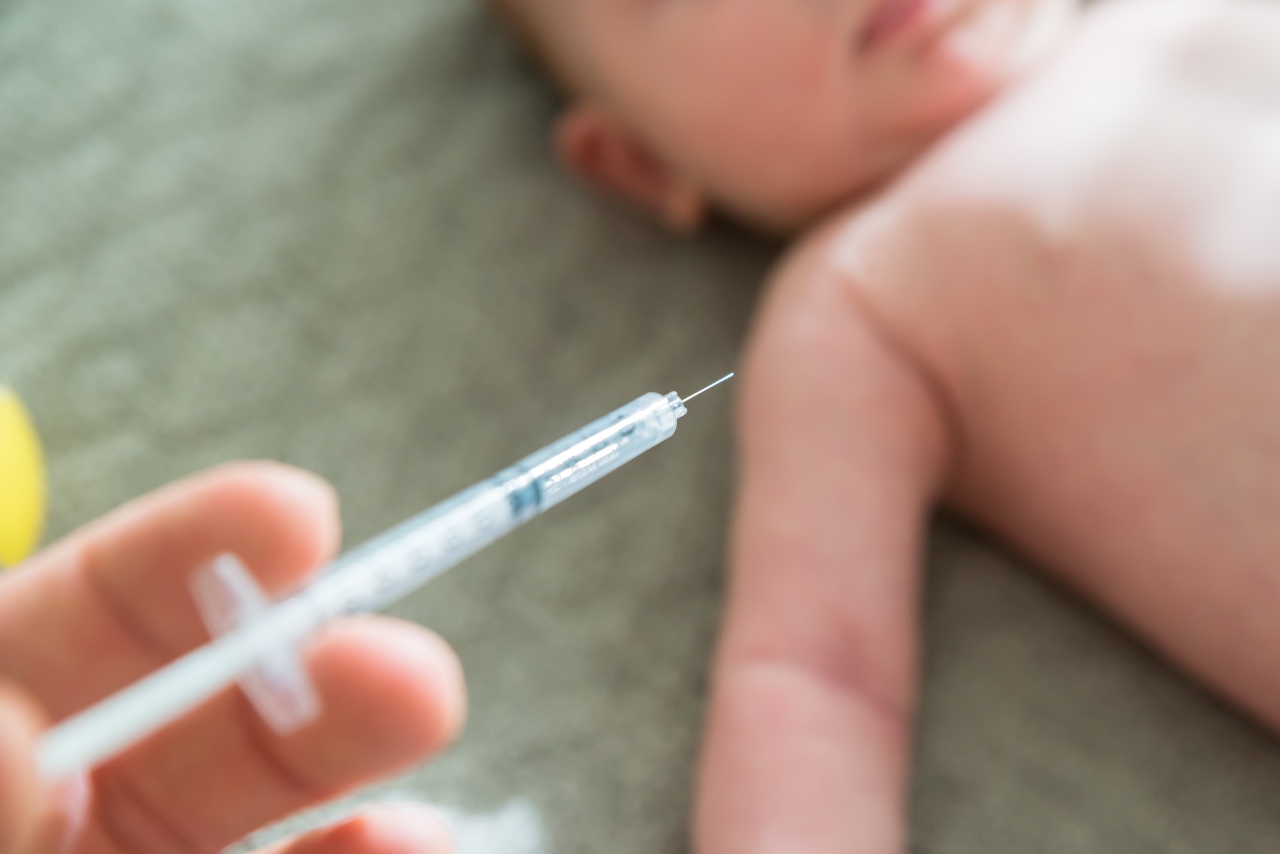 Spritze wird vor einem liegenden Baby gehalten