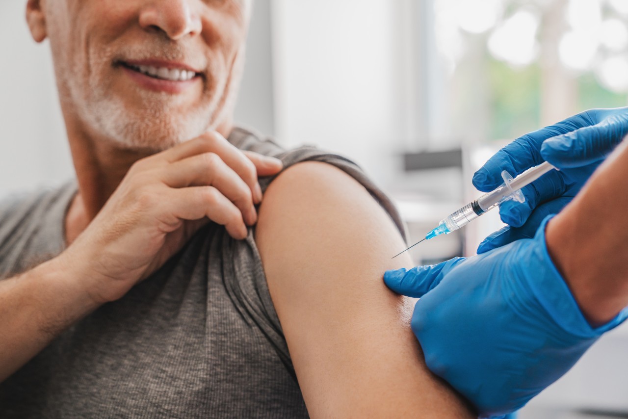 Älterer Mann wird in den Arm geimpft