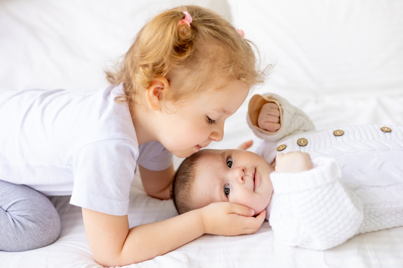 Ein kleines Mädchen küsst ein Baby